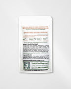 A single white stand-up pouch package photographed on a light gray background. The front is mostly blank, but the back shows product information including the brand name The RX Tea Shop, website text, ingredient mentions, icons, and a QR code.