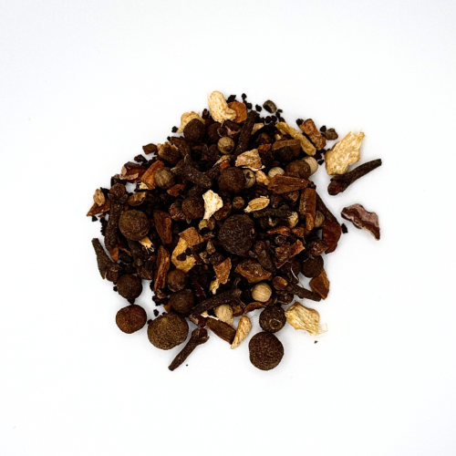 Spices including cloves and cardamom on a white background
