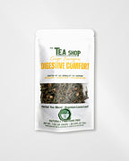 A stand-up pouch of 'The Tea Shop' Ginger Lemongrass Digestive Comfort herbal tea blend, featuring a white package with green and yellow text and a clear window showing the loose leaf tea inside.