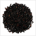 A pile of dried black elderberries with small reddish-brown stems, photographed from above on a white background.