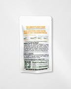 A white stand-up pouch of The RX Tea Shop herbal tea, photographed against a light gray background. The back of the pouch features orange and black text detailing the product's ingredients, benefits, and brand story, along with a QR code.