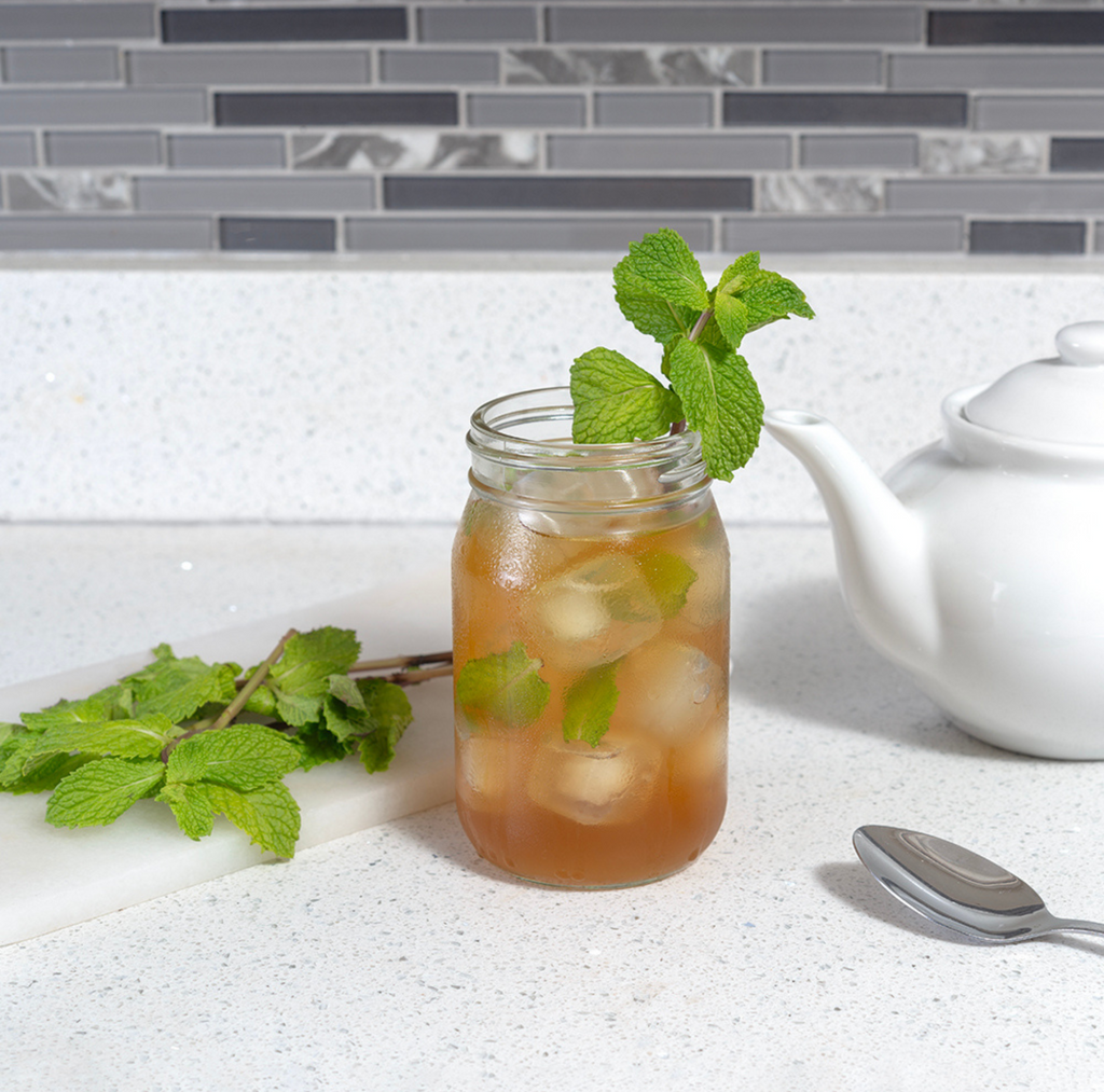Image of iced ghost mint tea with sprigs of peppermint in a clean kitchen with neutral tones