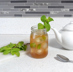 Image of iced ghost mint tea with sprigs of peppermint in a clean kitchen with neutral tones