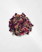 A small pile of dried rose petals and botanical pieces on a plain white background.