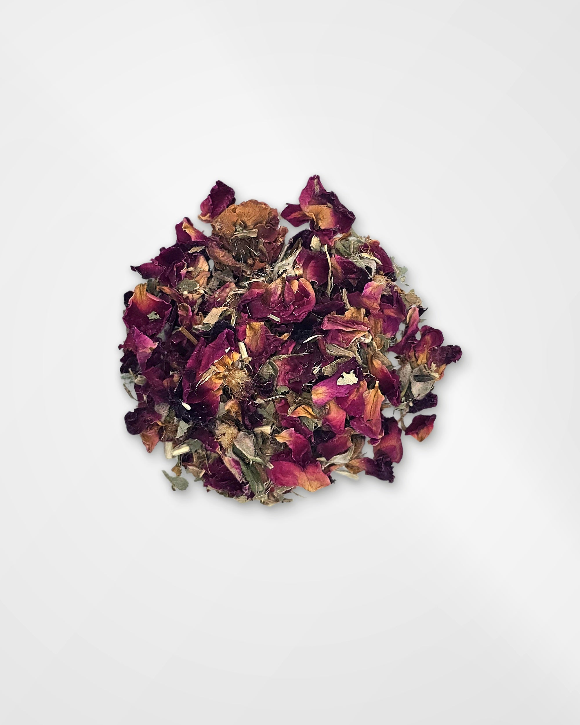 A small pile of dried rose petals and botanical pieces on a plain white background.