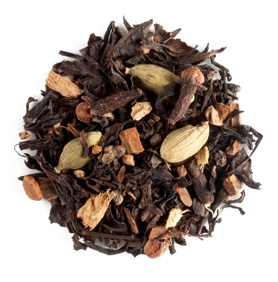Spiced black tea leaves with cardamom pods,cloves and ginger on a white background