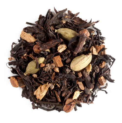 Spiced black tea leaves with cardamom pods,cloves and ginger on a white background