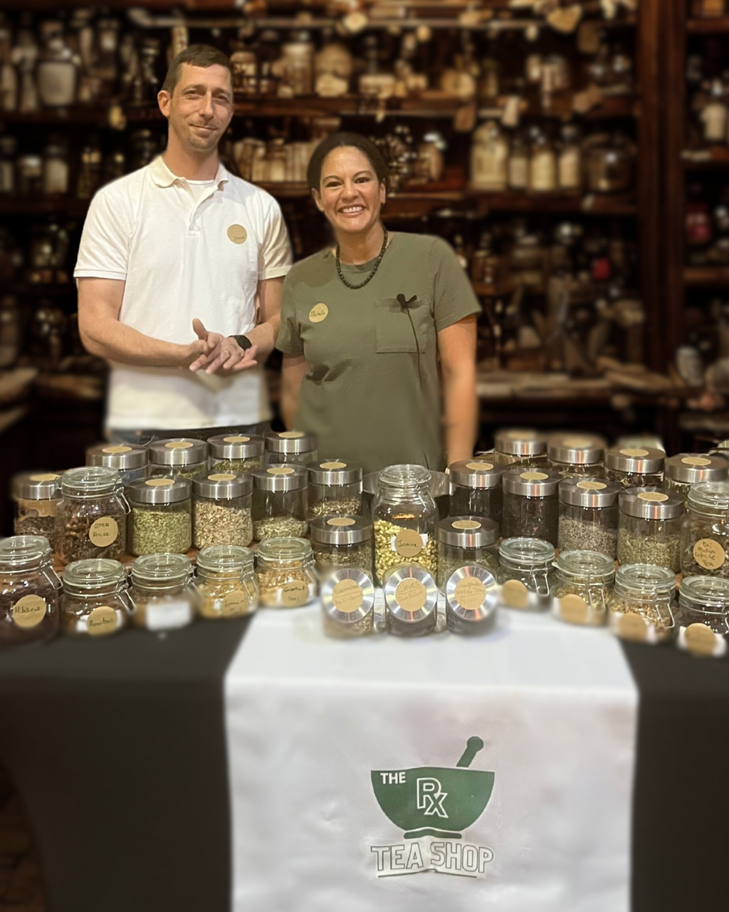 smiling woman and man with jars of herbs