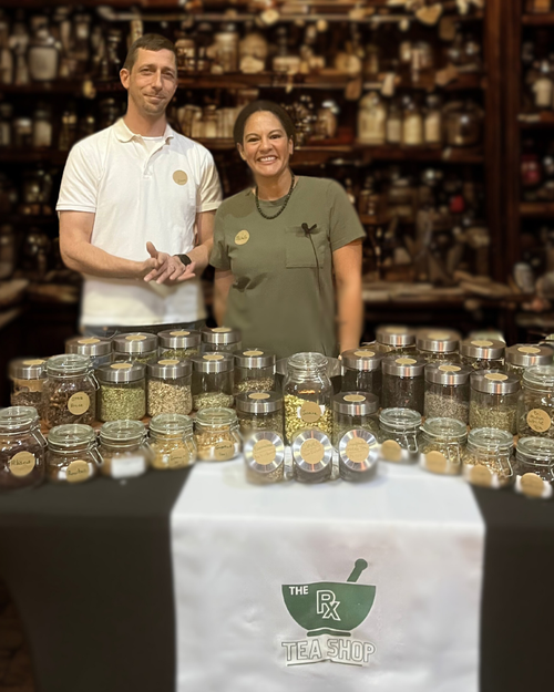 smiling woman and man with jars of herbs