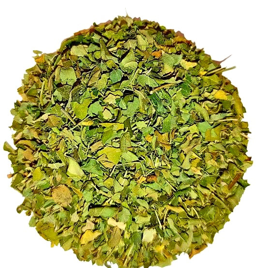 A circular pile of dried green leaves or herb pieces on a plain white background.