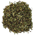 A pile of loose, dried peppermint  leaves on a solid white background 