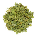 A pile of dried, chopped green leaves, likely herbal tea or botanical powder, isolated on a solid white background.