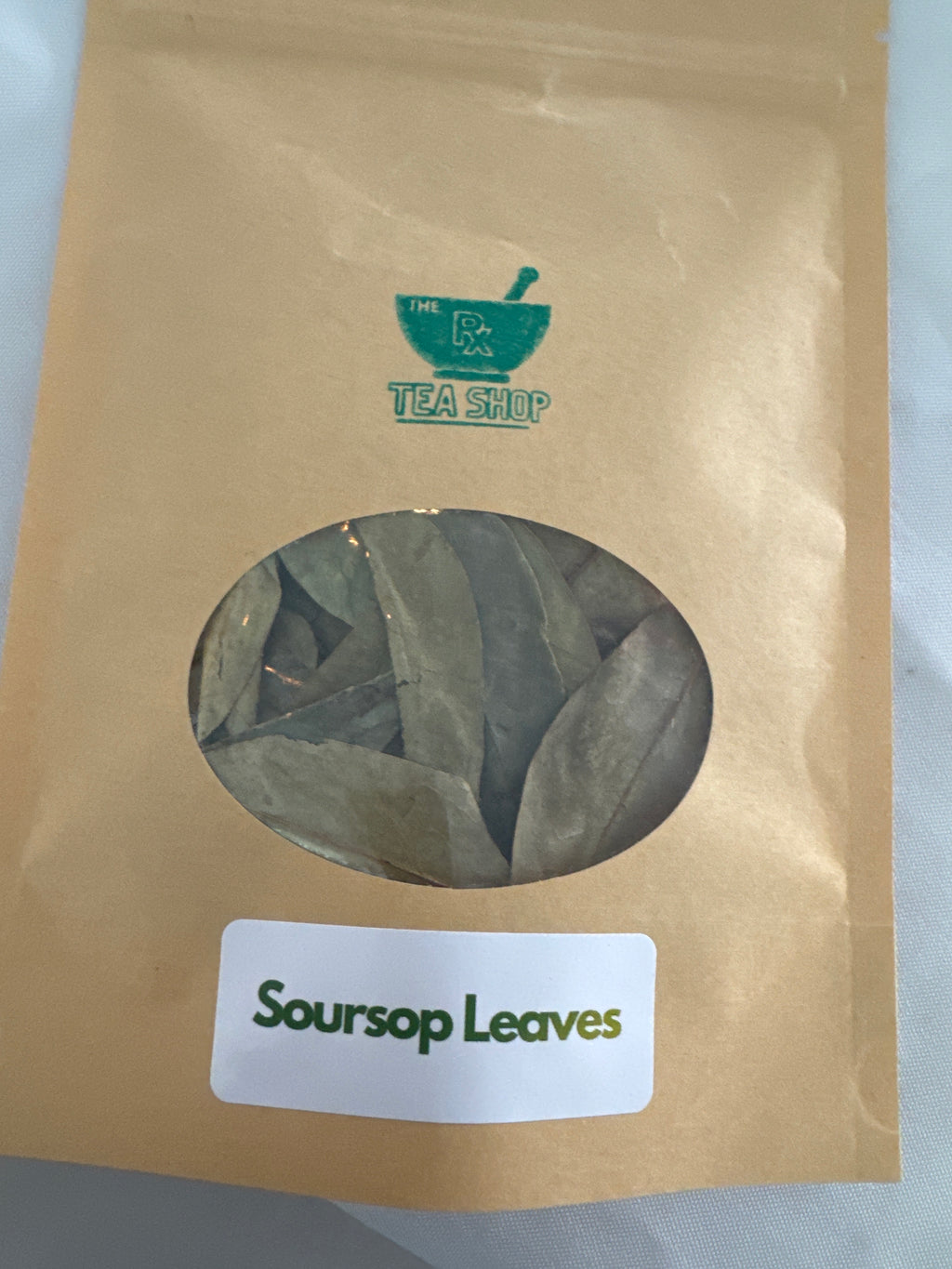 Close up image of large brown craft bag containing soursop leaves 