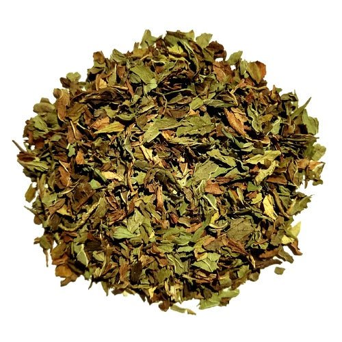 A pile of dried, chopped green and brown leaves, likely herbal tea or botanicals, isolated on a solid white background.