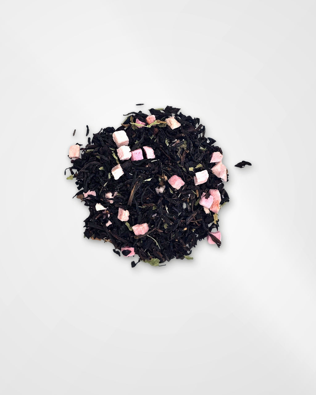 A small pile of loose-leaf tea blend on a plain white background, featuring dark tea leaves mixed with small pink pieces of air dried peach.