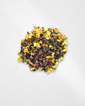 A small pile of loose-leaf herbal tea blend with visible yellow dried flower pieces, green leaves, and dark tea leaves on a clean white background.