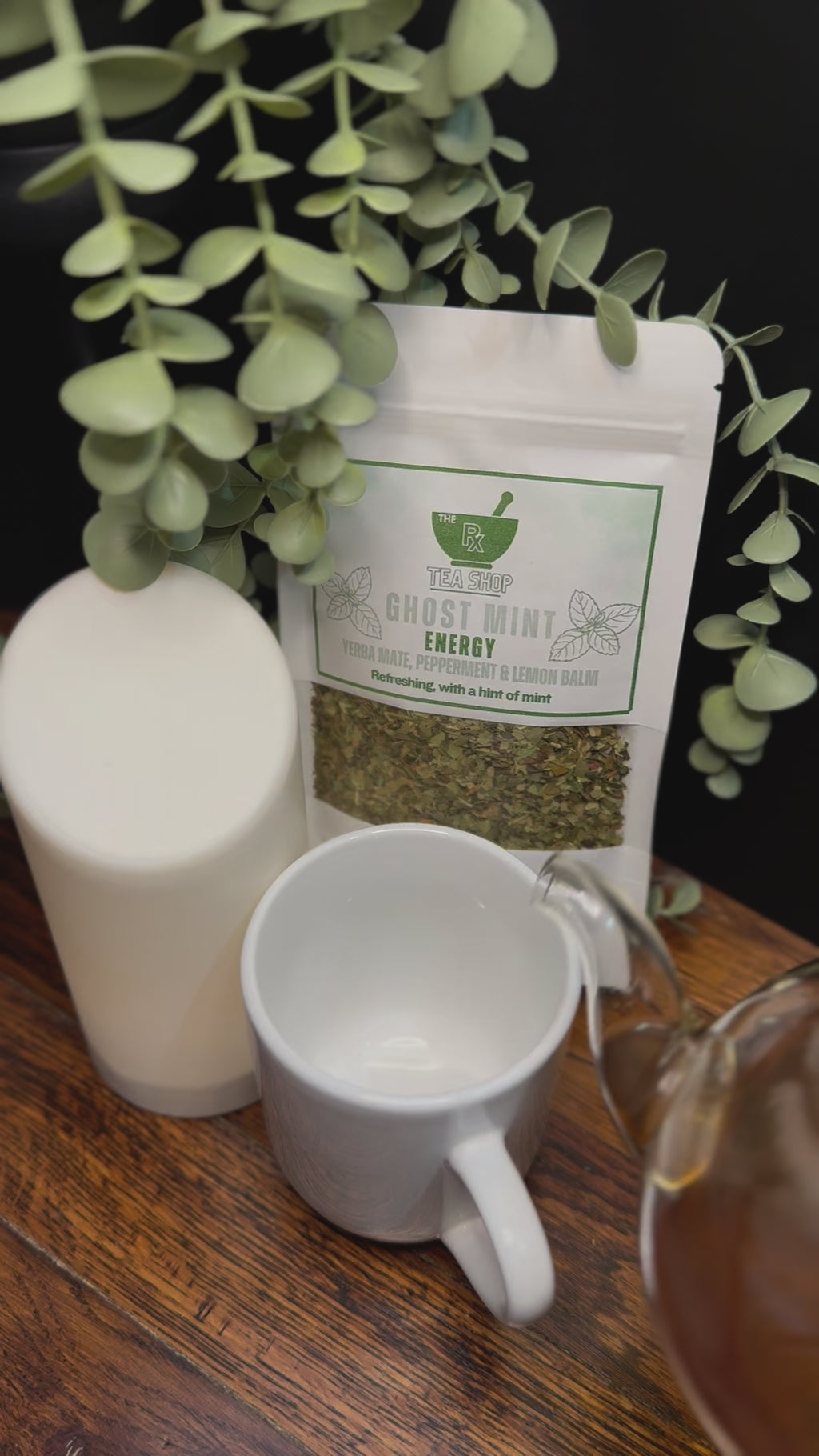 Short video clip of ghost mint tea being poured into white mug from clear teapot with green scenery