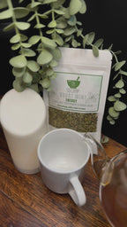 Short video clip of ghost mint tea being poured into white mug from clear teapot with green scenery