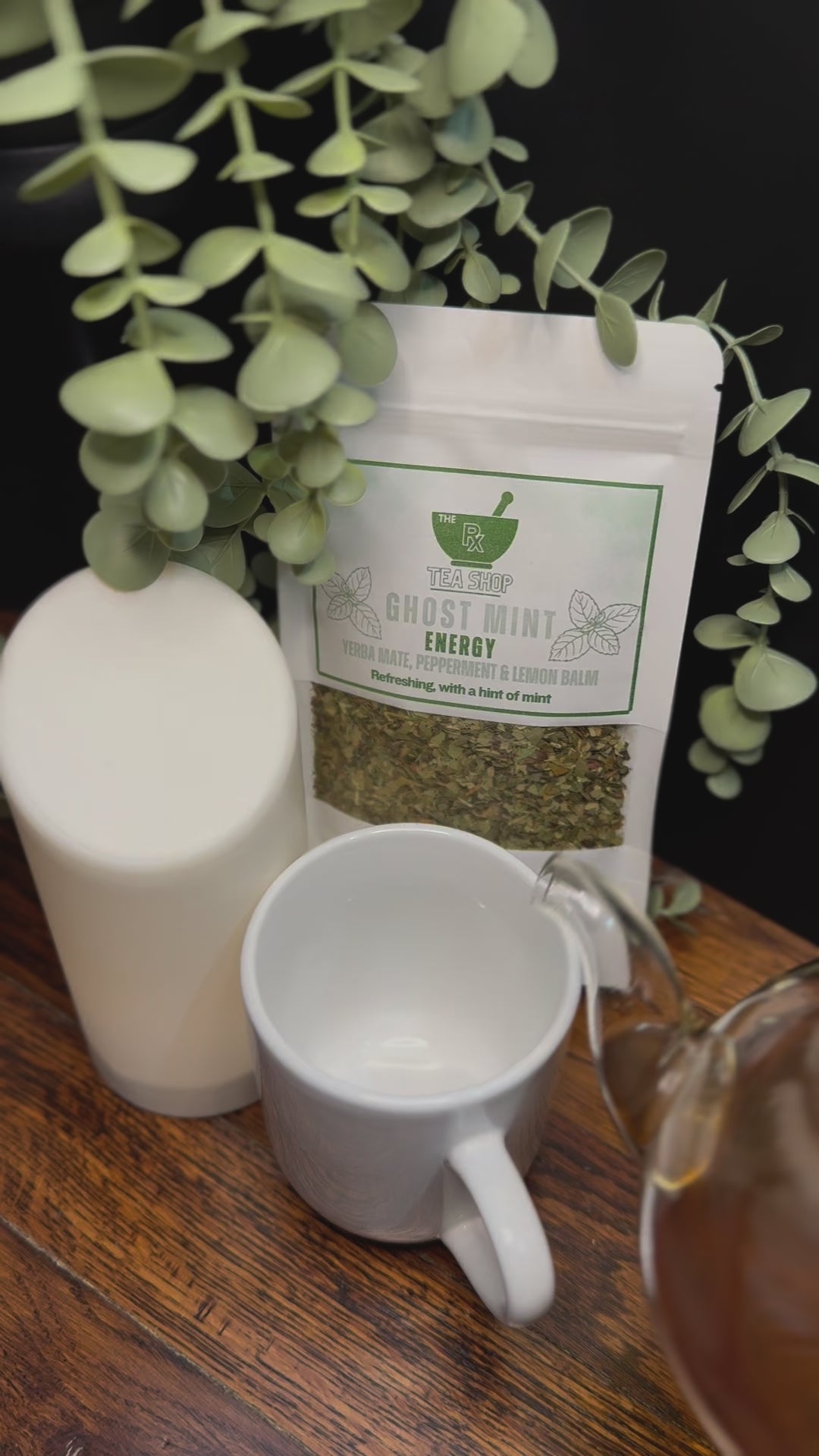 Short video clip of ghost mint tea being poured into white mug from clear teapot with green scenery