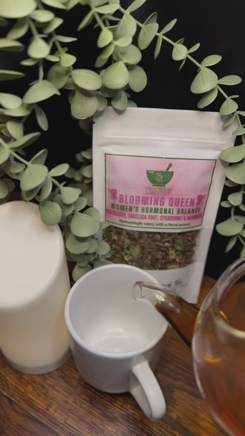 Short video clip of blooming queen tea being poured into white mug from clear teapot with green scenery 